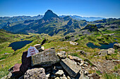 Summit cairn at Pic de Larry with mountain lake Lac Gentau and Pic du Midi, Vallee d'39; Ossau, Pyrenees National Park, Pyrenees, France