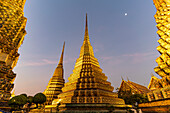 Chedis at Wat Pho Buddhist Temple at dusk, Bangkok, Thailand, Asia