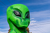 Wooden sculpture of little green alien characters. in New Mexico.