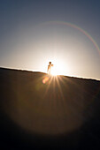 Silhouette eines Mannes, der auf einer Gipsdüne des White Sands National Monument in New Mexico steht.