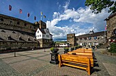 View from the flower-decorated square in front of Hotel Schloss Rheinfels to the battlements of Rheinfels Castle, the clock tower and the entrance area of the castle, St. Goar, Upper Middle Rhine Valley, Rhineland-Palatinate, Germany