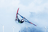 Windsurfer jumping in front of wind turbines, Baltic Sea, Schleswig-Holstein, Germany