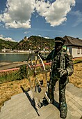 Statue des Steuermanns eines Schiffs am Rheinufer von St. Goar, im Hintergrund Burg Katz und St. Goarshausen, Oberes Mittelrheintal, Rheinland-Pfalz, Deutschland