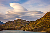 Das Ufer am See Pehoe mit Bergen und dramatischen Wolken bei Sonnenuntergang, Torres del Paine Nationaplark, Chile, Patagonien