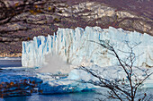 Abbruch einer großen Eismasse an der Abbruchkante mit spritzendem Wasser am Perito Moreno Gletscher, Nationalpark Los Glaciares, Argentinien, Patagonien