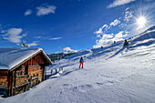 Frau auf Skitour steigt an Almhütte vorbei zum Schönbichl auf, Gerlos, Zillertaler Alpen, Tirol, Österreich