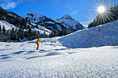 Woman on a ski tour climbs up to the scooter, Wechselspitze in the background, Scooter, Gerlos, Zillertal Alps, Tyrol, Austria