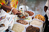 Pune, Indien, Gewürze werden gewogen und auf dem Markt an Käufer verkauft