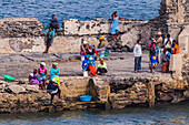 Women and men await the arrival of a fishing boat at the improvised harbour, Cape Verde Islands