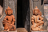 Two ornate Burmese guards sit at the entrance to a pagoda as a tomb in the In-Dein Pagoda Forest on Inle Lake, Myanmar, Asia