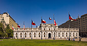 Der mondäne Palast Palacio de La Moneda mit chilenischen Flaggen im Regierungsviertel von Santiago de Chile, Südamerika