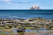 Blick auf Bass Rock mit Felsenstrand im Vordergrund, East Lothian Coast, Schottland, Vereinigtes Königreich