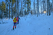 Man and woman winter hiking climb through snow-covered forest to the Großer Rachel, Großer Rachel, Bavarian Forest National Park, Bavarian Forest, Lower Bavaria, Bavaria, Germany