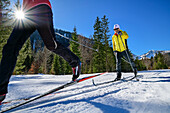 Man and woman cross-country skiing through the Kloo-Aschertal, Bayrischzell, Mangfall Mountains, Bavarian Alps, Upper Bavaria, Bavaria, Germany