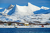 Snow-covered houses and mountains at Nordfjord, Nordfjord, Senja, Troms og Finnmark, Norway