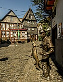 Statue eines Salmfischers und historische Bürgerhäuser in der Altstadt von St. Goarshausen, Oberes Mittelrheintal, Rheinland-Pfalz, Deutschland