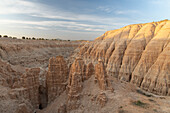 Felsnadeln stehen vor kleinem Canyon. Rechte Felswand wird von morgendlicher Sonne beleuchtet, Cathedral Gorge State Park, Nevada, USA