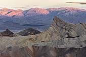 Sonnenaufgang mit Berg Glühen. Felsformationen im Vordergrund. Zabriskie Point, Death Valley, Kalifornien, USA