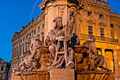 Statue of the sculptor and carver Tilman Riemenschneider at the Frankonia fountain in front of the Residenz at dusk, Würzburg, Bavaria, Germany