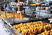 Shish kebab skewers and grilled Polish sausages at a street grill in Zakopane in Poland