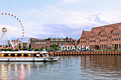 Bleihof Island (Ołowianka), Motława (Motlawa), Amber Sky Ferris Wheel (Koło Widokowe), Polish Baltic Philharmonic, Gdańsk lettering and excursion boat in Danzig (Gdańsk) in the Pomorskie Voivodeship in Poland