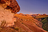 Sandstein-Felskopf in der Morgendämmerung mit Blick auf Drakensberge, Grindstone Cave, Injasuthi, Drakensberge, Kwa Zulu Natal, UNESCO Welterbe Maloti-Drakensberg, Südafrika