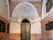 Gothic south portal and bronze door of the Cathedral of the Assumption of the Virgin Mary and St. Adalbert (Gniezno Cathedral; Archcathedral of Gniezno; Primate's Basilica of the Assumption of Our Lady; Bazylika archikatedralna Wniebowzięcia NMP) with Martyrdom of St. Adalbert in Gniezno (Gniezno) in the Wielkopolska Voivodeship of Poland