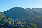 Wunderschöner Panoramablick über ein Dorf in Italien auf Berg und Tal mit Sonnenlicht und klarem blauen Himmel in der Lombardei, Italien