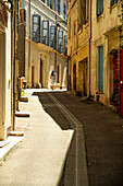 Frau geht an einem heißen Tag in Arles, Frankreich, die Straße entlang.