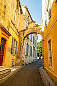 Arched stone gate in the medieval city of Arles, France