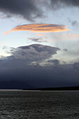 Chile; Südchile; Region Magallanes; Gebirge der südlichen Cordillera Patagonica; Seno Ultima Esperanza bei Puerto Natales; Regenwolken verdunkeln die Landschaft; Wolke von der Sonne angestrahlt;