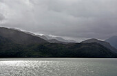 Chile; Südchile; Region Magallanes; Gebirge der südlichen Cordillera Patagonica; auf der Navimag Fähre durch die patagonischen Fjorde; Angostura Inglesa oder English Narrows; tief hängende Regenwolken; Regen