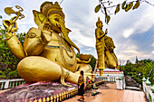 Tourist in front of the huge golden Ganesha statue of the Buddhist temple Wat Mokkanlan in Chom Thong, Thailand, Asia