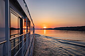 Fensterspiegelung an Bord von Flusskreuzfahrtschiff Maxima (Nicko Cruises) auf der Donau bei Sonnenuntergang, in der Nähe von Golubac, Caraș-Severin, Rumänien, Europa
