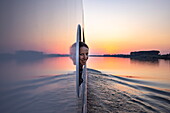 Lächelnde Frau schaut durch Fensteröffnung an Bord von Flusskreuzfahrtschiff Maxima (nicko cruises) auf der Donau bei Sonnenuntergang, in der Nähe von Golubac, Rumänien, Europa