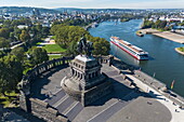 Aerial view of river cruise ship Rhein Melodie (nicko cruises) on the Moselle as it passes Deutsches Eck with equestrian statue of German Emperor Wilhelm I, Koblenz, Rhineland-Palatinate, Germany, Europe