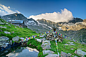 Stone man with prayer flags and Kasseler Hütte in the background, Kasseler Hütte, Stilluptal, Zillertal Alps Nature Park, Zillertal Alps, Tyrol, Austria