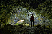 Frau beim Wandern steht in Höhle Finsteres Loch, Rosenstein, Heubach, Schwäbische Alb, Baden-Württemberg, Deutschland