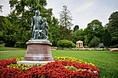 UNESCO Welterbe "Die bedeutenden Kurstädte Europas", Lanner- und Strauss Denkmal im Kurpark mit Mozarttempel im Hintergrund, Baden bei Wien, Niederösterreich, Österreich, Europa