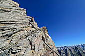 Mann klettert durch Felswand auf Zsigmondyspitze, Zsigmondyspitze, Zillertaler Alpen, Naturpark Zillertaler Alpen, Tirol, Österreich