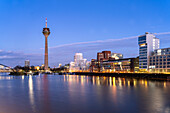  Gehry buildings - Neuer Zollhof at Medienhafen and the Rhine Tower in Düsseldorf at dusk, North Rhine-Westphalia, Germany 