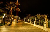 Allegorische Statuen an der Seepromenade von Ceuta bei Nacht, Straße von Gibraltar, Spanien