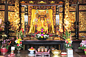 Goldener Altar mit Blumenschmuck und Opfergaben in der Halle der Kaiserin Zhusheng im Dalongdong Baoan Temple, Taipeh, Taiwan, Asien