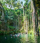 Menschen schwimmen im Kalksteinbecken, Cenote Ik Kil, Pisté, Yucatan, Mexiko