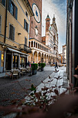 Strassencafe mit Stühlen in Gasse mit Glockenturm und Dom, Cremona, Provinz Cremona, Lombardei, Italien, Europa