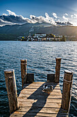  Wooden jetty with ducks, view of Isola San Giulio from the port of Orta San Giulio, Piazza Motta, Orta San Giulio, Lake Orta is a northern Italian lake in the northern Italian, Lago d&#39;Orta, or Cusio, region of Piedmont, Italy, Europe 