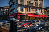  Rowing boats in the foreground, view of Isola San Giulio from the port of Orta San Giulio, Piazza Motta, Hotel Leon d&#39;Oro in the background, Orta San Giulio, Lake Orta is a northern Italian lake in the northern Italian, Lago d&#39;Orta, or Cusio, region of Piedmont, Italy, Europe 