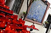 Kerzen und kleine Andachtsstätte vor einer kleinen Kirche in Sevilla, Andalusien, Spanien