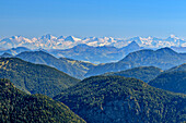 Blick über die bewaldeten Gipfel der Tegernseer Berge auf die Hohen Tauern vom Großen Wiesbachhorn bis zum Großglockner, Hirschberg, Bayerische Alpen, Oberbayern, Bayern, Deutschland