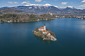 Luftaufnahme der Marienkirche im Bleder See und der verschneiten Berge in Bled, Slowenien, Europa.
